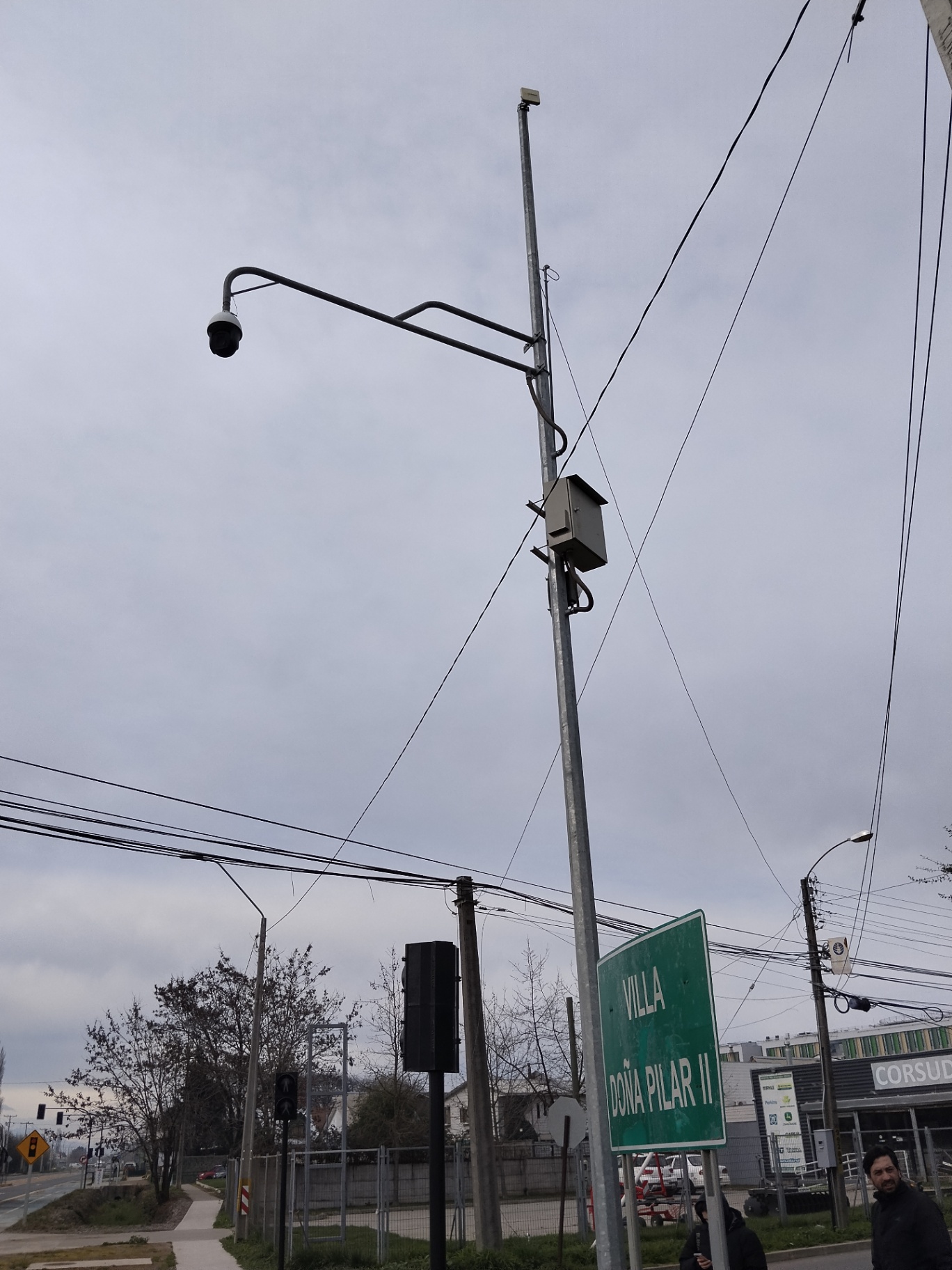Poste metálico con cámara IP, antena de radioenlace y gabinete de intemperie instalado en una villa